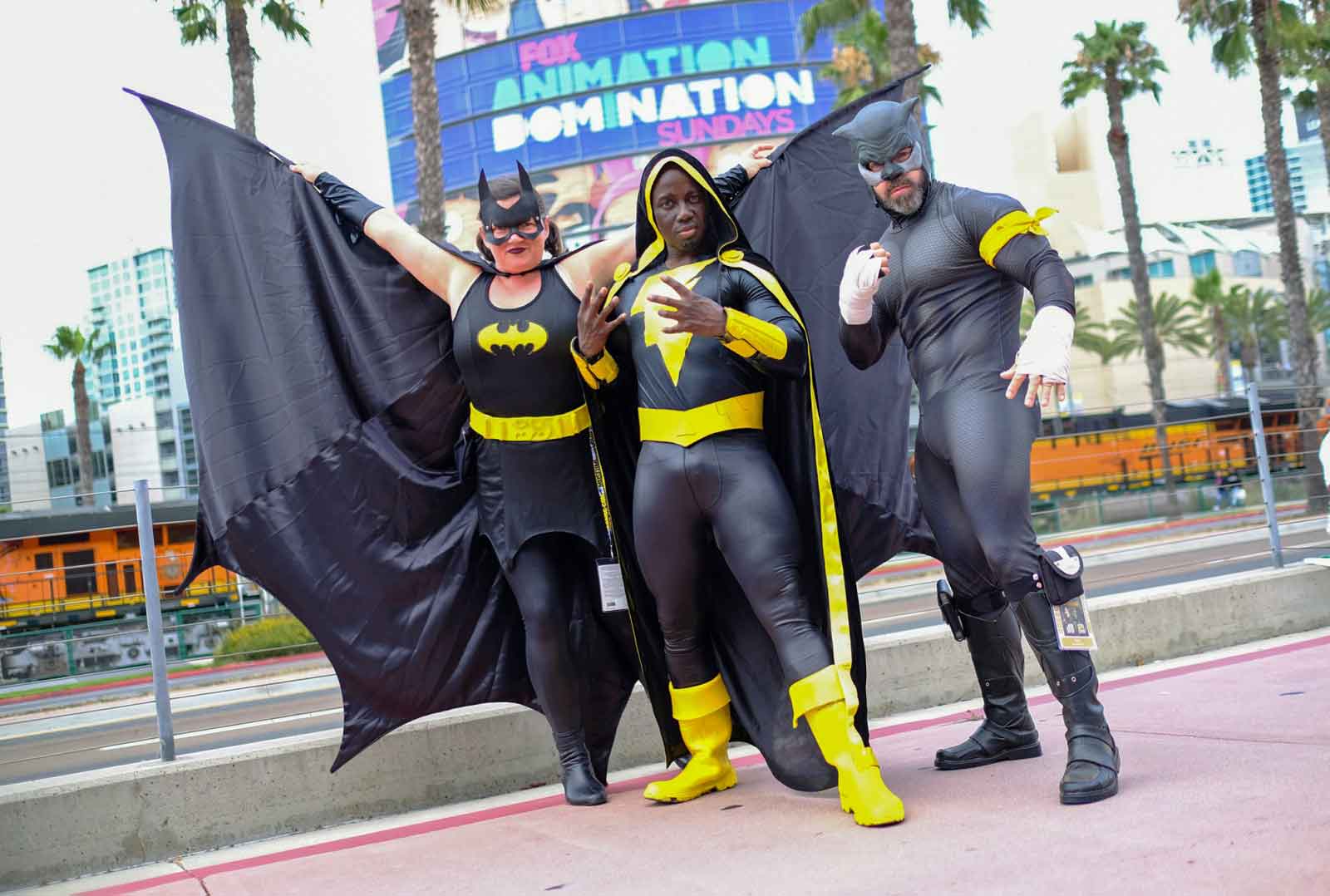 Die Cosplayer Faera Adams (Batgirl), Jay Acey (Black Adam) und Derek Shackelton (Wildcat) posieren vor dem Convention Center während der Comic Con in San Diego im Juli 2019. (Foto: Chris Delmas/AFP)