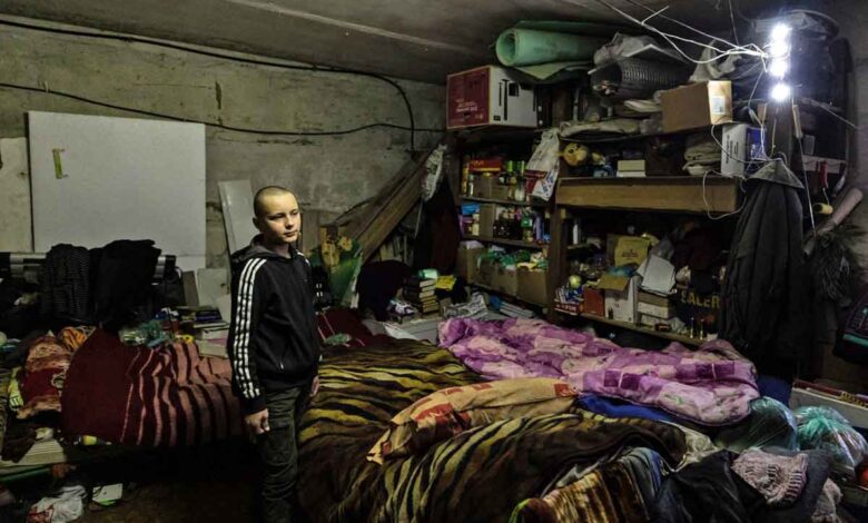 Gleb Petrov, 14 Jahre alt, am 21. Dezember 2022 mit seiner Familie in einem Keller in der Stadt Bachmut in der Ostukraine. (Foto von Sameer Al-DOUMY / AFP)