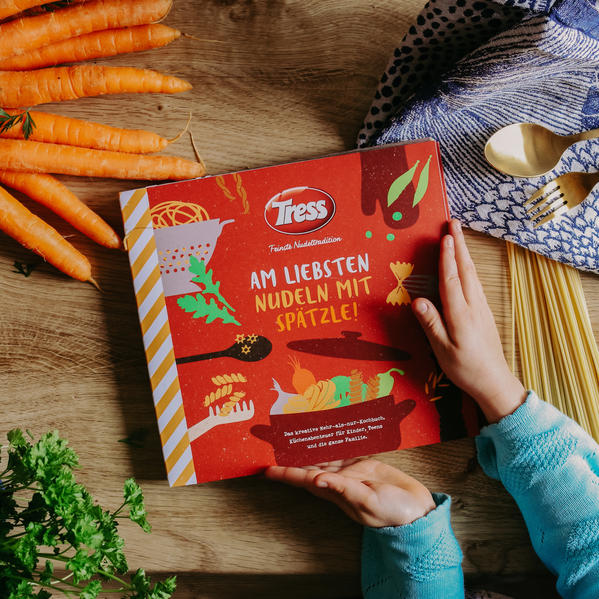 Das Kinder- und Familienkochbuch „Am liebsten Nudeln mit Spätzle“ ist da! Die Nudelexperten von Tress - feinste Nudeltradition, haben viele Gedanken, Spaß und Herzblut hineingesteckt und möchten Nudel- und Kochbegeisterung in illustrierter Buchform weitergeben. Im Mehr-als-nur-Kochbuch warten kurzweilige und lehrreiche Ausflüge in die Küchenwelt, spielerische Erzählungen über Stil- und Ernährungskunde sowie Hinweise zu einem bewussteren Umgang mit Abfällen durch Re- & Upcycling-Ideen. Doch nicht nur das: Ein Mitmach-Kapitel füllt Wartezeiten beim Kochen mit Rätsel-, Mal- und Bastelspaß für Freunde und die ganze Familie. Zusätzlich ist das ‚‚Mehr-als-nur-Kochbuch" digital erweiterbar. Durch das Scannen des abgedruckten QR-Codes oder über https://www.tress.de/kinderkochbuch können weitere Informationen sowie Einkaufslisten und Bastel-Anleitungen abgerufen bzw. gedownloadet werden. Dieses Zusatzmaterial wird laufend ergänzt. Das ‚‚Mehr-als-nur-Kochbuch" stellt das gemeinsame Kochen, Essen und ein angenehmes Miteinander von Familie und Freunden am Tisch in den Mittelpunkt gestellt. Denn was gibt es schöneres, als ein leckeres, harmonisches Essen mit den Liebsten?!