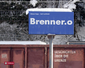 Brenner-Geschichten Wichtigster Alpenübergang, Wasserscheide, Transitroute, Einkaufs- und Ausflugsziel, Grenze, Tor zum Süden: Der Brenner war und ist für die Menschen nördlich und südlich der Grenze so vieles, fast immer aber ein emotionaler Ort. Zum Brenner fuhren schon die Eltern und Großeltern zum Einkaufen. Der Süden war hier zumindest kulinarisch ganz nah, die Brennerjause fixe Institution. Auf dem Rückweg fanden Wein, Parmesan und andere Köstlichkeiten oft den Weg an den Zöllnern vorbei, sehr zur Freude vieler Tiroler, die den Brenner sowieso nicht so recht als Grenze akzeptieren wollten. Warum auch, denn die Teilung des Landes vor fast 100 Jahren wurde von vielen als historisches Unrecht angesehen. Nicht immer passierten also nur Alkohol und Käse die Grenze. Waffen und Sprengstoff waren ebenfalls in den Kofferräumen der Autos versteckt, diesmal Richtung Süden. Der Traum von der Wiedervereinigung erfüllt sich nicht, mit Autonomie und Wohlstand kam eine Anpassung an die Begebenheiten. Othmar Kopp hat sich in seinem Projekt intensiv mit dem Brenner auseinandergesetzt, mit dessen historischer und aktueller Bedeutung, mit dessen Mythos. Seine Fotografien zeigen einen Ort, der sich zwischen den Welten befindet und bis heute eine ganz eigene Ästhetik zwischen Verfall und Neubeginn sein eigen nennt. Etliche Motive sind im kollektiven Tiroler Gedächtnis eingebrannt, von vielfachen Fahrten in den Norden oder Süden. Das Eisenbahnschild „Brenner – Brennero“, die Remise, die Bahnhofsreste und der Uhrturm, die Stände mit den Lederwaren, der Brennermarkt. Auch neue Bilder sind in den letzten Jahren dazugekommen: Flüchtlinge auf dem Weg in den Norden, aufgehalten von den Behörden, in Warteposition im Niemandsland zwischen Verzweiflung und Hoffnung. Das Porträt des Brenners, auch anlässlich seiner „Entstehung“ als Grenzort vor 100 Jahren, aber gleichzeitig aktuell und am Puls einer bewegten Zeit. Mit einem Essay von Kurt Lanthaler und zahlreichen Beiträgen von Künstlern, Fernfahrern, Eisenbahnern, Ausflüglern, Brenner-Liebhabern und vielen anderen, denen der Brenner auf die eine oder andere Art ans Herz gewachsen ist.