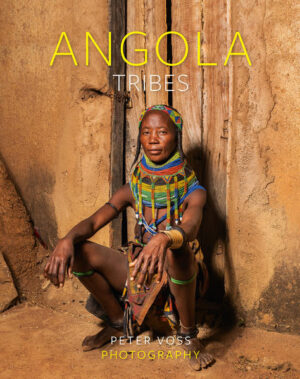 Angola – I love this land – is on the move and I visited it again for several weeks in August/September 2021. After 30 years of civil war and 10 years now of stable peace, the country is still in its infancy with regard to tourism. Even for those with travel experience in Africa, Angola is one of the last “blank areas” on the continent so that there are as good as no tourists here, let alone photographers. The city of Luanda is counted incidentally as the most expensive capital worldwide and is also called the “Dubai of Africa”. Huge offshore reserves of gas and oil have completely upset the price structure. Angola is an emergent regional power in southern Africa – a country with an unparalleled balancing act in the face of its incredible wealth of mineral resources and concurrent enormous poverty. A small state elite profits from this and casts a hopeful eye on capital markets abroad. The rapidly growing young population lives for the most part in poverty, however, and the gap between rich and poor is especially wide here. There is extreme inequality between the social classes in Angola – and it is chronic. Only a very small minority wallows in opulent luxury. The country itself, three times the size of Germany, is a land of great contrasts, a huge puzzle of different climatic zones, landscapes and cultures, characterised by the alternation between tradition and modernity. The population of Angola is similar to most countries in the region with regard to its structure. With the exception of the small group of Khoisan living in the southwest, all the other Angolan ethnic groups belong to the Bantu group. The very small group of Europeans consists largely of people of Portuguese origin. They found the correct language designations too difficult and so there are two names for all of Angola’s indigenous tribes. When the country became independent in 1975, there was a mass exodus of the Portuguese. And with them went also the expertise and capital denied to the Africans. However, the common language up to today is Portuguese. My journey began with the landing in the capital Luanda, where approximately 10 million people live, and from there went in a southerly direction along the coastal road, often with pleasant views of the sea and the beach. The eight-hour journey took me first to Benguela. My first resting place – and last one in a hotel – was in this lively town with its 3 million inhabitants. The next morning I continued south – another eight hours in the jeep – as far as the province of Namibe, home of the Herero groups, in this case also known as Himba or Ovahimba. (Fig. 1) They also live by the river Kunene in northern Namibia. On my numerous trips to the former German colony I had already been fascinated by this ethnic group with their red body painting (red granite dust mixed with fat). They are nomadic hunters, gatherers and cowherds and are part of the Bantu language group. Some of them also moved to southern Angola in the 16th century. I spent my first days “in the bush” and in my tent in the region around Virei. The Mucubal (Ovakuvale) also live here. Their hair adornments are known as ompota. The cord around the female breast is called oyonduthi and serves as a kind of bra. (Fig. 2) My journey led me further to Oncocua, Pediva and Otechifengo in order to be close to the Mucawana (Ovahakaona). They, too, are wonderful, peaceable people who often live so isolated that they hardly know white people. (Fig. 3) In the following days we drove over dirt tracks in the direction of Cahama. I was able to meet another indigenous tribe, the Mumuhuila (Ovamwila). Their wonderful hairstyle with the unusual plaits with mud crusts and the colourful neckbands (Vikeba) I would like to call art. Great craftsmanship is required here to create this. (Fig. 4) The wonderful moments with the people I met on this journey form my most important memory and were a priceless experience. Even in the most remote “bush” we were never alone. Alone the sound of our vehicle’s engine roused the curiosity of the natives, for it signalled that strangers were coming! Almost every morning when we crawled out of our tents, several inhabitants – often with children – were already standing within due distance from us, observing exactly what we were doing. After breakfast we usually invited them to come closer and gave them rice, pasta, fruit, bread or sweets. A subsequent photo shooting often then developed. My two wonderful guides Jake and Mario always made very friendly contact with the natives during our trip and gave me a signal when I could take photos. Following this I always thanked them in the local currency – and the people were usually then radiant, for they knew that they would now be able to make ends meet financially for a week or more. I had also brought a lot of bags with me from Germany containing small lighters, combs, mirrors, pencils, toys, ballpoint pens and many other articles – all things which were also very gratefully received. We gave out sweets, biscuits and chocolate amongst other things to the children. The children are real treasures, extremely interested and approachable, for our visit brought a little variety to their everyday life as cow or goat herds or water carriers. If the school is too far away, their entire life consists of these very strenuous activities. Several times we were invited extremely warmly to village festivals