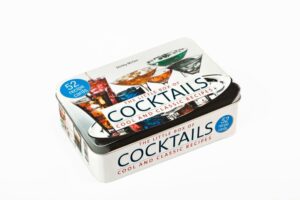 Geschenkbox für Cocktail-Fans! Das ideale Mitbringsel zur Cocktail-Party Dekorative und hochwertige Geschenkbox aus Metall Die 50 besten Rezepte mit und ohne Alkohol Ob geschüttelt oder gerührt, mit oder ohne Alkohol - diese Rezeptbox präsentiert die 50 besten Cocktails für Hobbymixer und Barprofis von klassisch bis exotisch, immer ergänzt durch Rezeptvarianten und Tipps zur Auswahl der richtigen Gläser. Ob Aperitif, Longdrink, Shot, Sektcocktail, Bowle oder Digestif – die übersichtlichen und handlichen Karten liegen stets griffbereit in Ihrer Bar!