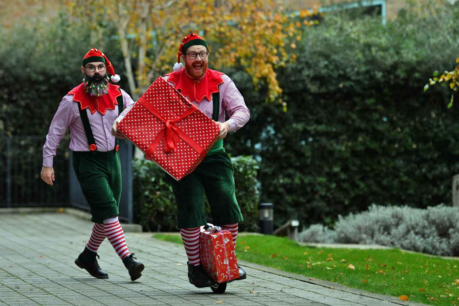 Die Elfen des Weihnachtsmanns treten am 30. November 2021 vor dem Ministry of Fun in London auf, während sich die Weihnachtsmänner in der Santa School versammeln, einer Reihe von Schulungskursen für professionelle britische Weihnachtsmänner. Letztes Jahr war das erste in über 20 Jahren Santa School, in dem sich die Weihnachtsmänner nicht traditionell versammeln konnten. (Foto von JUSTIN TALLIS / AFP)