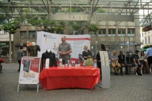Der Infostand "Lies! Der edle Fantasyroman auf Deutsch" des Bundesamtes für magische Wesen auf dem Friedensplatz in Bonn
